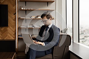 Focused young male employee working on computer.