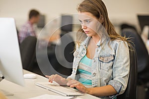 Focused young student working in the computer room