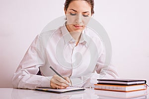 Focused young woman entrepreneur deep in thought, working at table writes notes