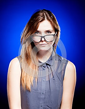 Focused young woman looking through nerd glasses