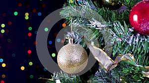 Focusing Christmas tree with gold glitter ornament and blinking lights