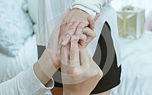 Focusing on man& x27;s hand wearing a ring to girlfriend finger