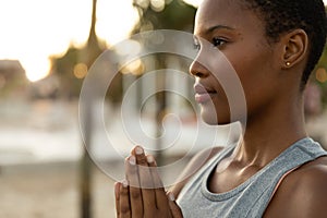 Focussed african american woman practicing yoga meditation on sunny beach, copy space photo