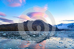 Foehn cloud - Lenticularis - over mountains reflecting in ocean with ice floes, South Georgia