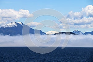 Fog bank on ocean in Alaska with mountains