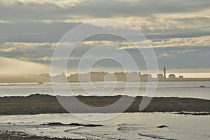 Fog and cloud banks intermingle over Lighthouse Point Metis