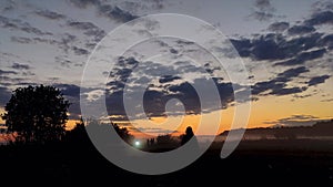 Fog in the field. sunset. silhouettes of a group of people. motorcycle headlights