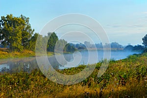 Fog or haze over the lake on a summer morning. Beautiful countryside