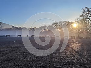 Fog in lake pamvotis of ioannina city greece in winter morning sunrise among leafless  trees