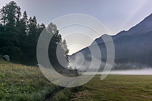 The fog and mist rising from the plains around the lake of Silvaplana in the Engadin valley at sunrise