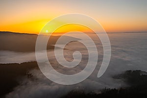 Fog in the mountain valley at dawn. The morning in the haze. Aerial drone view.