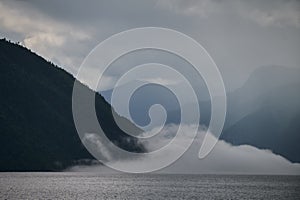 Fog in the mountain valley. Morning fog over the lake in the Altai mountains.