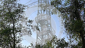 Fog passes over 5G LTE cell tower antenna installation on a power line pylon