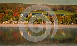 Fog rises over the lake at sunrise on a chilly morning as fall foliage peaks through the mist