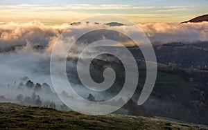 Fog rising over the rural hills at dawn