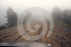 Fog road in mountains, spring mysterious journey travel by car in mist, toned