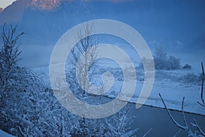 Fog and snow on the banks of the river photo