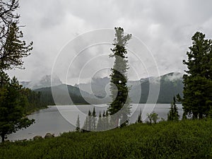 Fog spreads over Svetly Lake in the mountains of Ergaki Natural Park