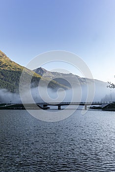 The fog surrounding the bridge on the lake of Silvaplana in the Engadin valley at sunrise