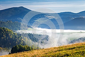 Fog in the valleys of the mountain landscape in autumn morning