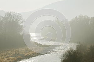 Fog visible in the riverbed. Autumn landscape