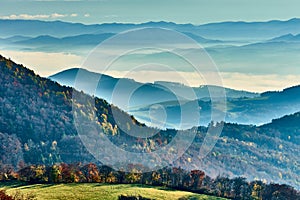 A foggy autumn landscape with mountain , the sun breaking through the clouds. View from Vrsatec hill, Slovakia.