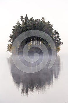 Foggy autumnal morning by the lake. Natural sunrise light. Trondheim area in Norway