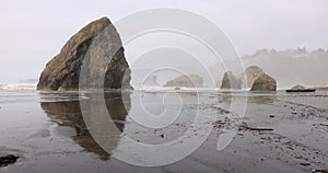 A foggy beach with rocks and a rocky shoreline