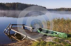 Foggy lake with bridge and boat