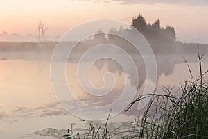 Foggy landscape of early morning before sunrise over a river