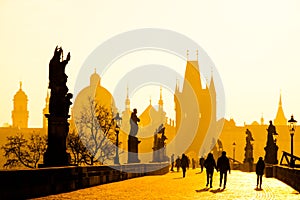 Foggy morning on Charles Bridge, Prague, Czech Republic. Sunrise with silhouettes of walking people, statues and Old