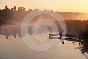 Foggy morning over calm river, pink fog against morning sun, fisherman place. Ukraine, peace