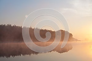 Foggy morning over calm river, pink fog against morning sun, full moon. Ukraine, peace