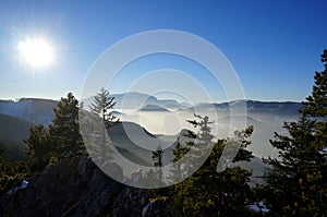 Foggy mountain landscape in Austria. Beautiful mountain valley filled with early morning mist. Dramatic foggy mountain range rise