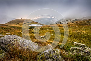 Foggy Mountain Landscape with a Tarn at Sunset