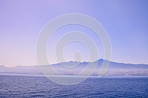 A foggy mountain range is visible in the distance behind a calm body of water