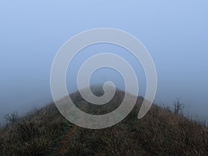 Foggy outdoor scene with hills and trails