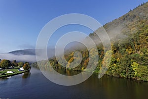 Foggy river landscape and forest in autumn colors