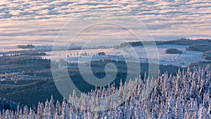 Foggy valley with cloud rolling over the hills at sunrise in winter