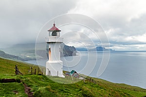 Foggy view of old lighthouse on the Mykines island