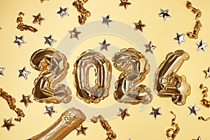 Foil gold air balloons in the form of number 2024 on yellow background with confetti stars and party streamers