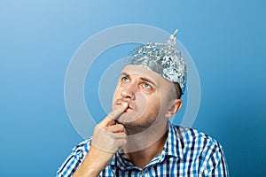 Foil hat on man. Man with a pensive face. Protects from reading think