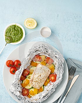 Foil pack dinner with white fish. Oven baked fillet of cod, pike perch with vegetables