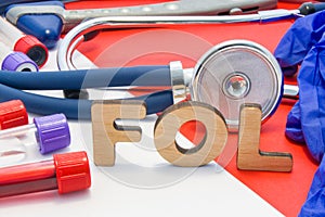FOL medical abbreviation meaning total folate or folic acid in laboratory diagnostics on red background. Chemical name of FOL is s