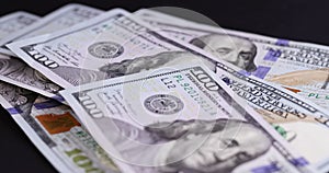 fold American cash bills hundred dollar bills on black paper