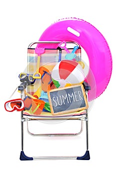 Foldable beach chair full of beach items on a white background