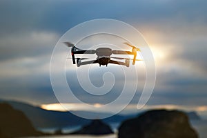 Foldable drone copter flying with a digital camera in mountains.