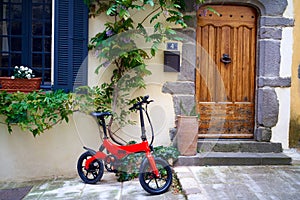 Foldable electric bike in a smaal town at the front door