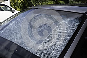 Foldable reflective sunshade on the inside of a car windshield