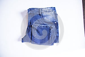 folded blue jeans pants isolated white background